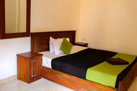 Carved wooden bed with a lime green runner